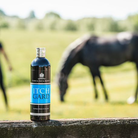 bottle of Itchgard on a fence
