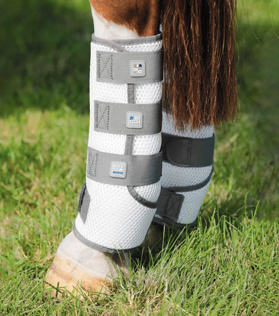 Horse leg with protective boot on grass
