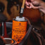 Carr & Day & Martin Neatsfoot Compound can with a brush being dipped into it, set against a blurred background.