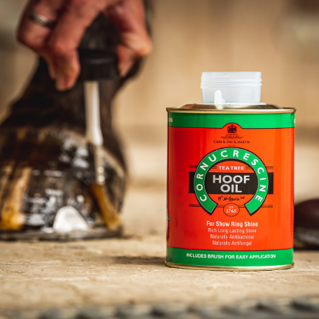 Cornucrescent Hoof Oil can with a horse hoof in the background