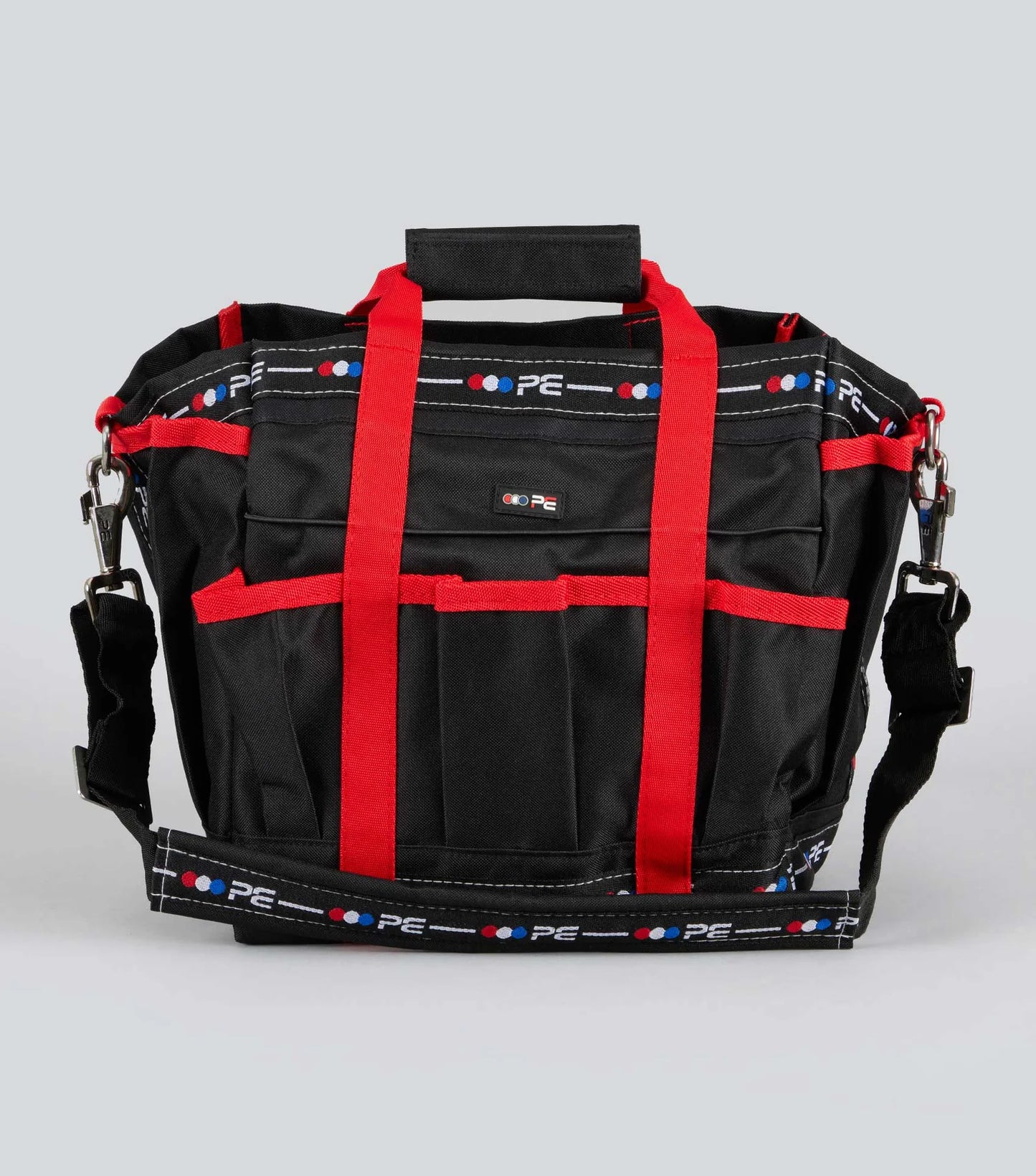 Black Premier Equine grooming bag with red straps on a gray background