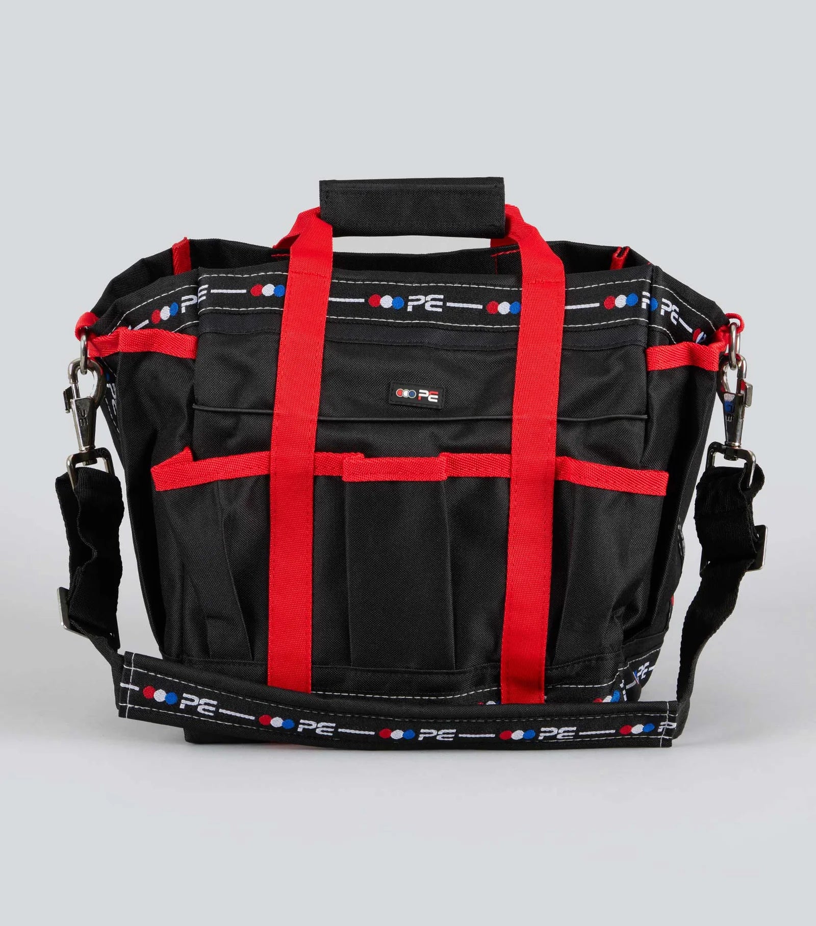 Black Premier Equine grooming bag with red straps on a gray background