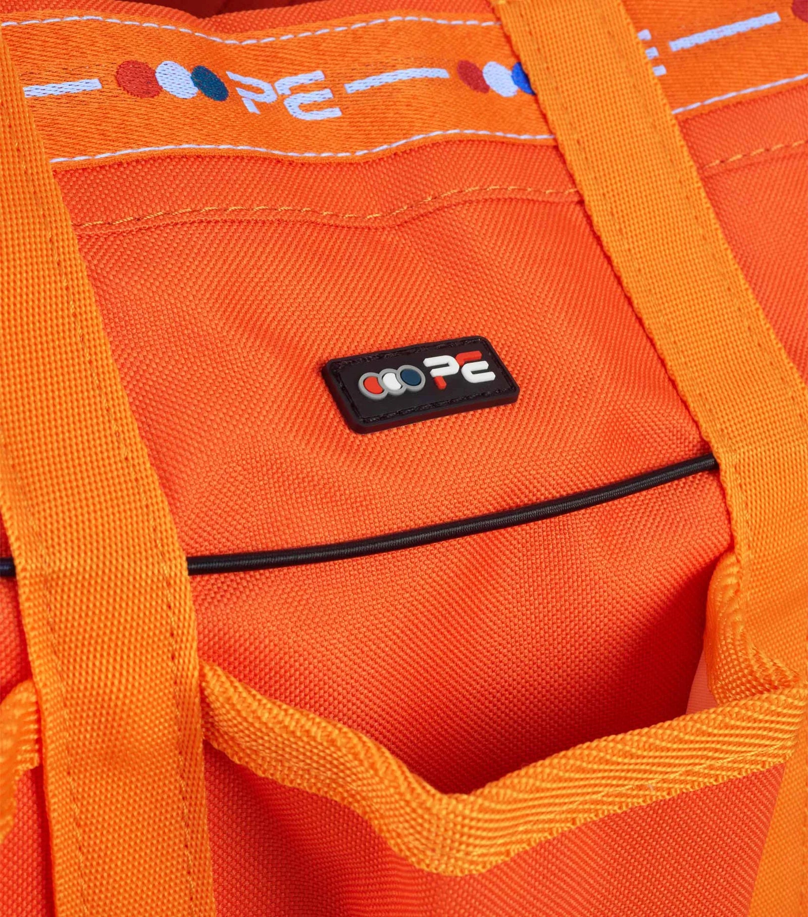 Close-up of an orange bag with Premier Equine brand logo on a matching background