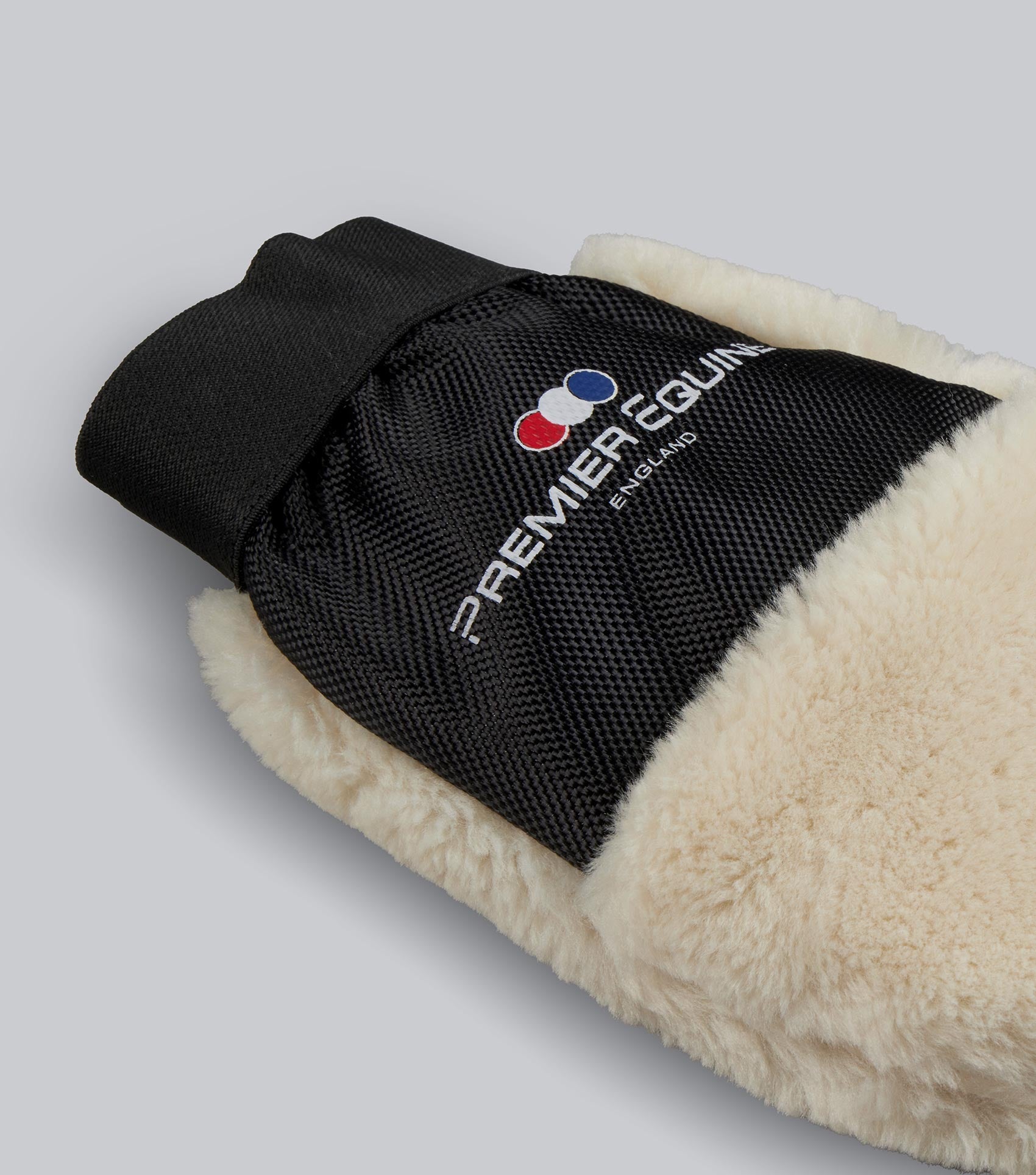 Black and cream mitt with 'Premier Equine' logo on a light gray background