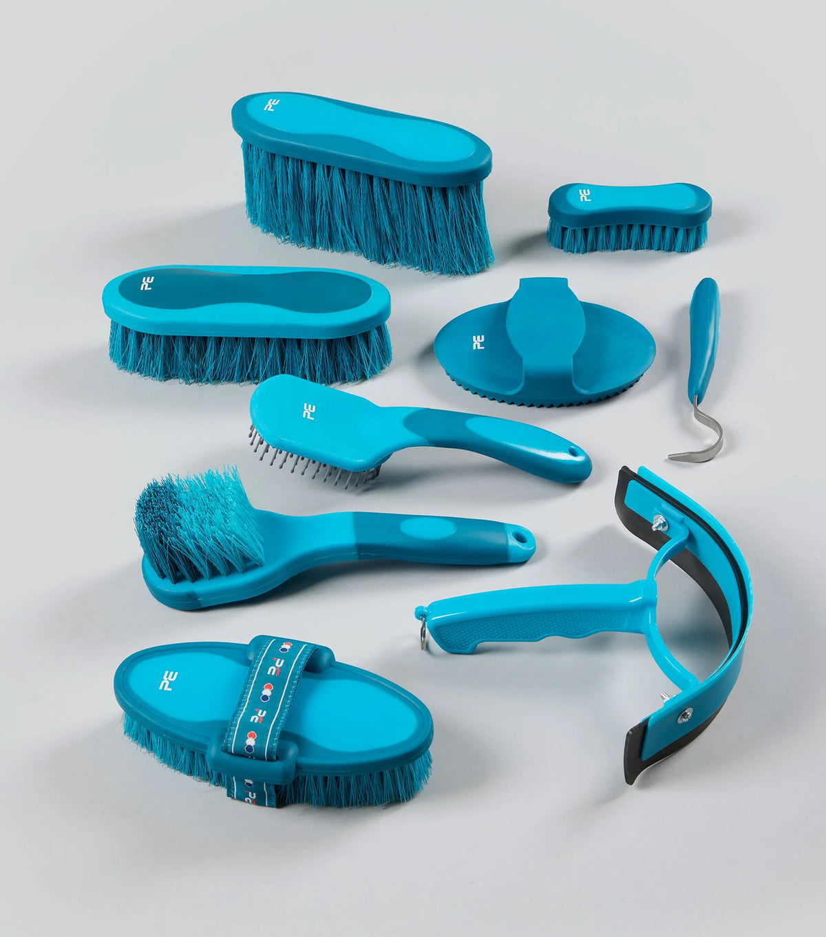 Set of blue grooming brushes and tools on a light gray background