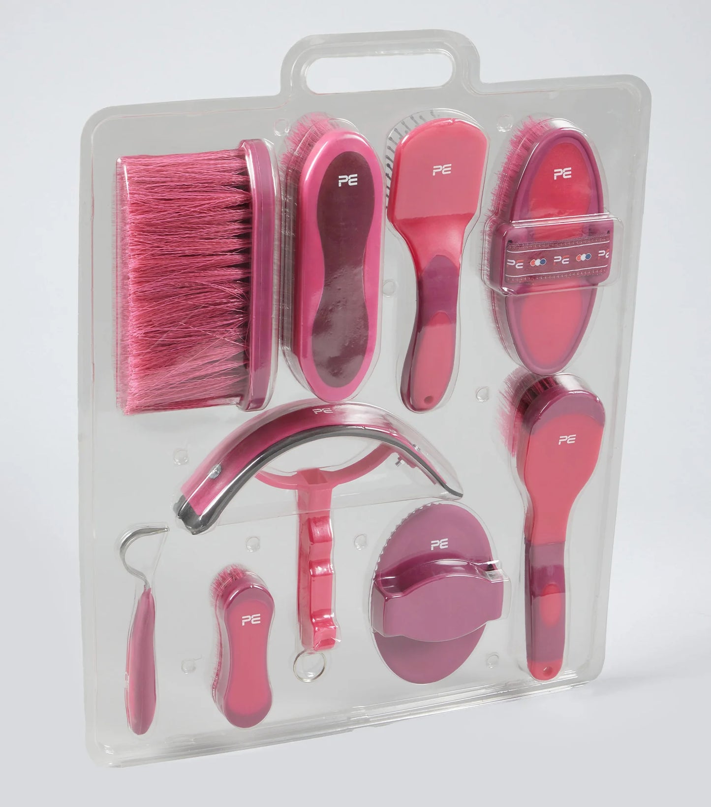 Set of pink grooming tools for pets in clear packaging on a white background