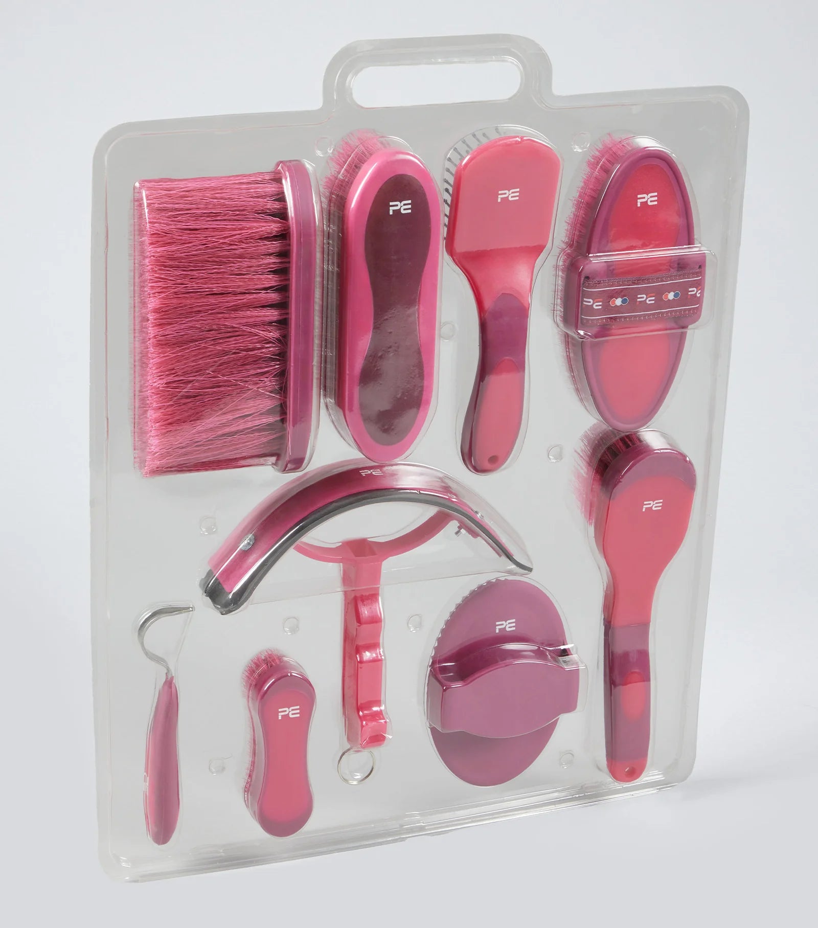 Set of pink grooming tools for pets in clear packaging on a white background