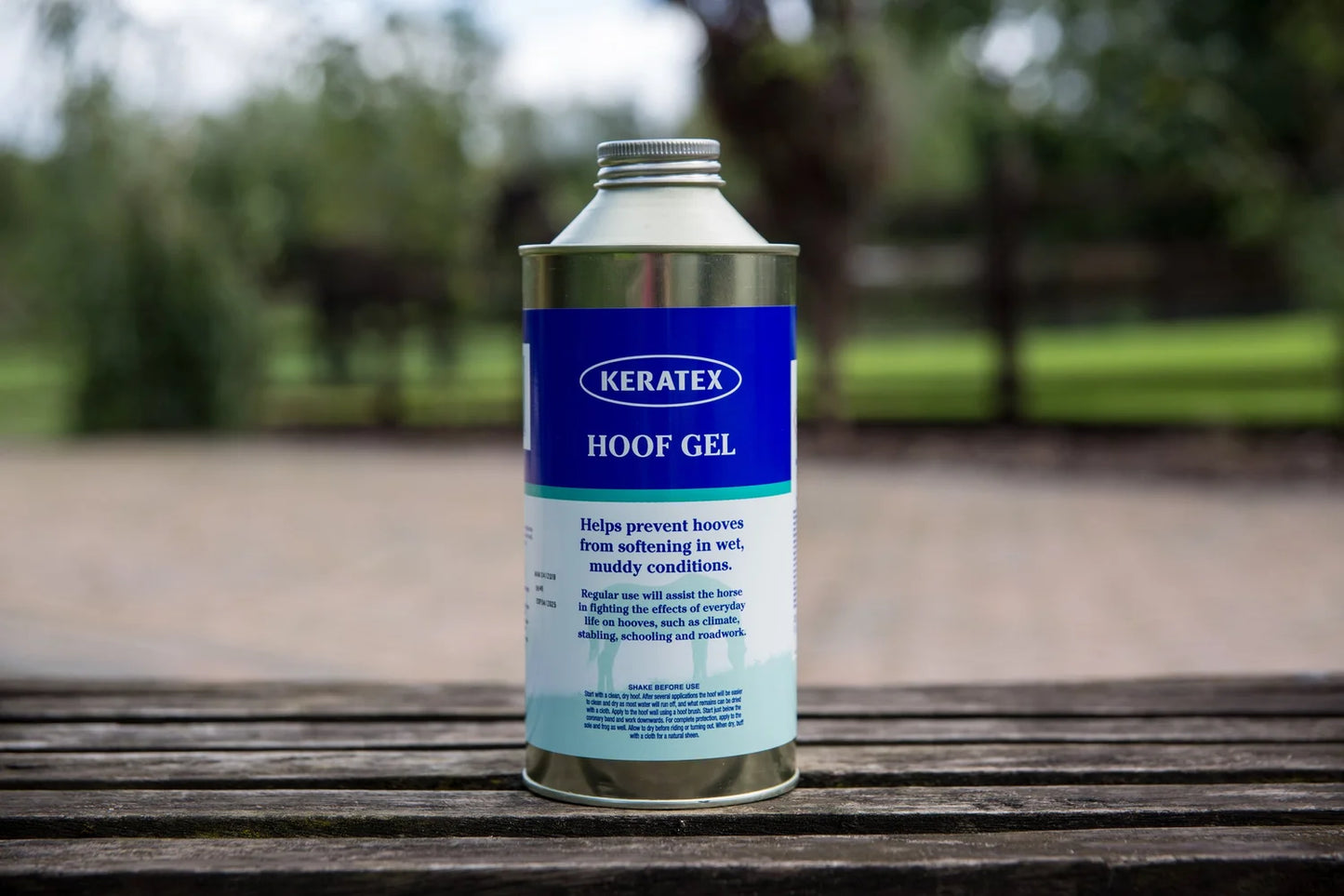 Keratex Hoof Gel can on a wooden surface with a blurred outdoor background